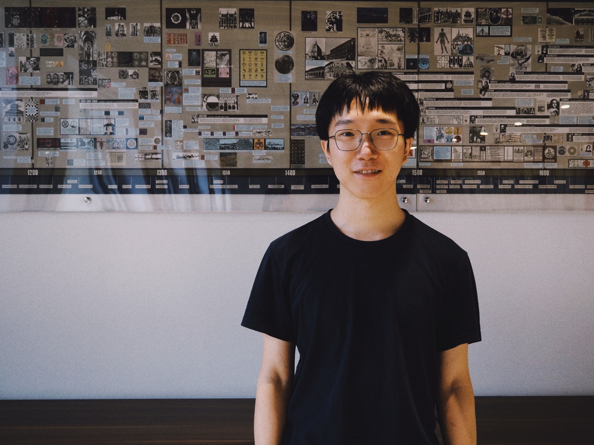 Ziyuan Zhao standing in front of an exhibit on the history of mathematics